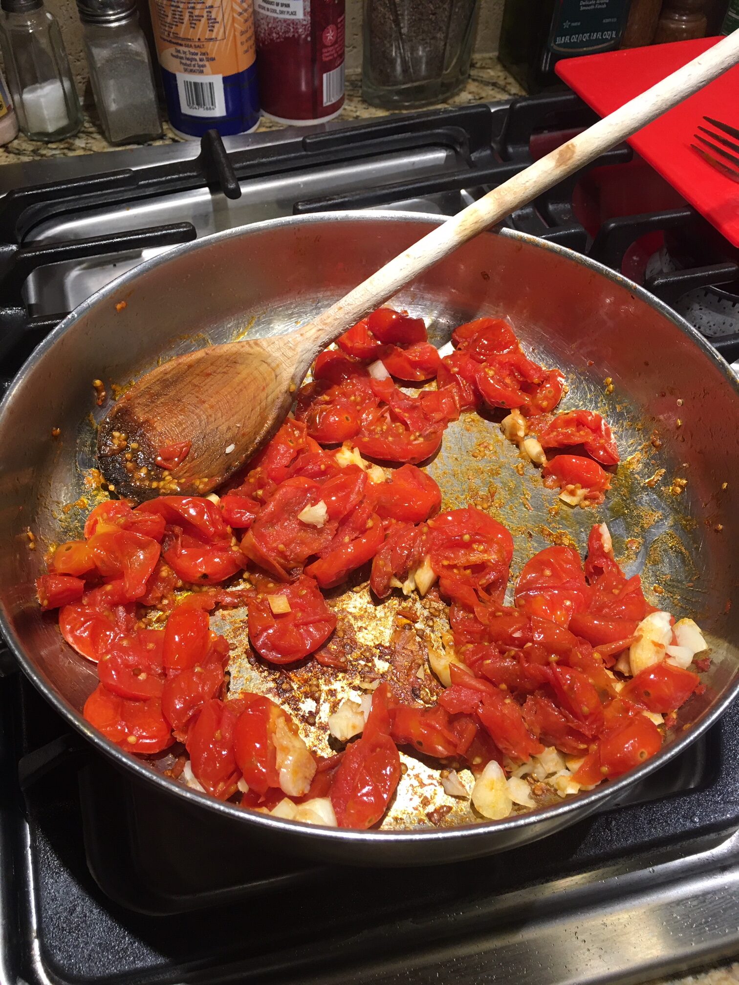 Cherry tomatoes with garlic popping in the pan as a base for pasta sauce