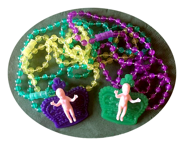 New Orleans Mardi Gras beads and king cake babies in seasonal colors of purple, green and gold